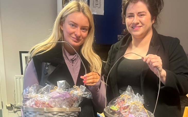 Picture of two ladies holding an Easter basket with chocolates inside.